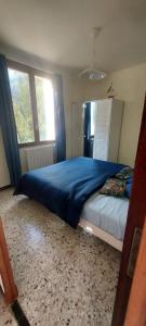 a bedroom with a bed with a blue blanket on it at Villa Maison de campagne 04 Vacheres Luberon 3 chambres 8 personnes in Vachères