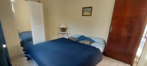 a bedroom with a blue bed and a door at Villa Maison de campagne 04 Vacheres Luberon 3 chambres 8 personnes in Vachères