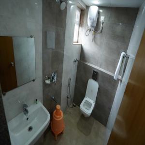 uma casa de banho com um lavatório, um WC e um espelho. em Happy Nest Guest Home em Kurmannapalem