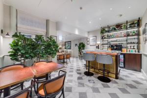a restaurant with tables and chairs and a bar at Mornington Hotel London Kensington, BW Premier Collection in London