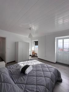 Casa Branca في Ribeiras: غرفة نوم بسرير كبير ونافذة كبيرة