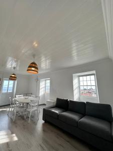 Casa Branca في Ribeiras: غرفة معيشة مع أريكة سوداء وطاولة