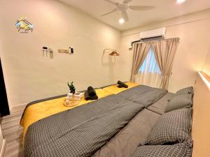ein Schlafzimmer mit einem großen Bett und einer gelben Decke in der Unterkunft Kota Laksamana Homestay-22pax with Karaoke,Arcade Game,Table Pool in Malakka