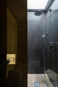 bagno con doccia e porta in vetro di Casa de Triana Luxury Suites by Casa del Poeta a Siviglia