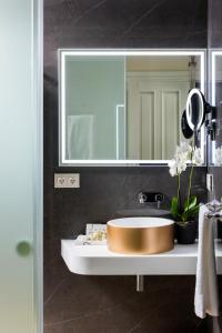 a bathroom with a sink and a mirror at Casa de Triana Luxury Suites by Casa del Poeta in Seville