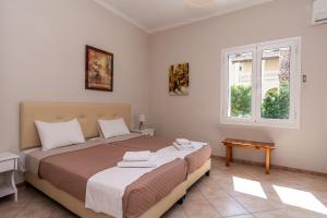 a bedroom with a bed and a window at Mentikas Studios in Laganas