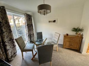 sala de estar con mesa, sillas y ventana en Swallows Cottage Coniston, en Coniston