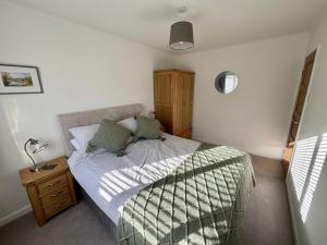 a small bedroom with a bed and a night stand at Swallows Cottage Coniston in Coniston
