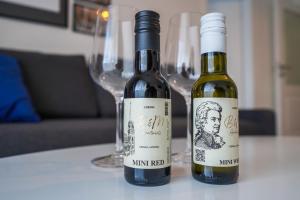 zwei Flaschen Wein auf einem Tisch mit Weingläsern in der Unterkunft BelVie Residence in Wien