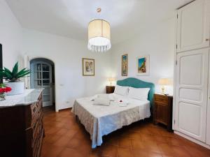 Schlafzimmer mit einem Bett und einem Kronleuchter in der Unterkunft YourHome - Maison Iolanda Positano in Positano