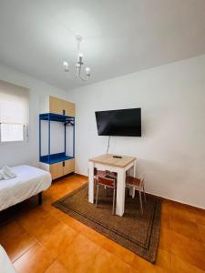 Habitación con mesa, cama y TV. en Escuela Village, en Marbella