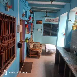 a living room with blue walls and a chair at Suraj Guest House in Varanasi