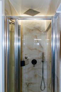 La salle de bains est pourvue d'une douche avec une porte en verre. dans l'établissement Casa Cecilia, à Casamassima
