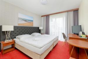 a hotel room with a bed and a desk and a computer at Gryf Resort Międzywodzie in Międzywodzie +95 photos