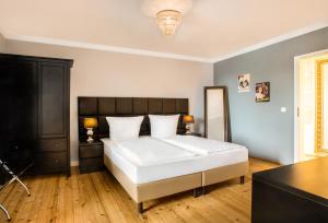 1 dormitorio con 1 cama blanca grande y suelo de madera en Hotel Royal Jülich en Jülich