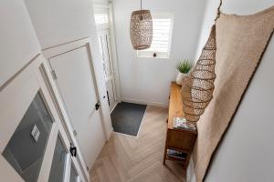 a staircase in a home with a hallway with white walls at Bamboa Beachhouse in Zandvoort