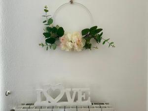 a wreath on a wall with flowers and a love sign at In campagna in Besozzo