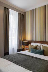 Un dormitorio con una cama grande y una ventana. en Best Western Mornington Hotel Hyde Park, en Londres