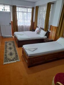 salon z 2 łóżkami i kuchnią w obiekcie Yalung Homestay w mieście Dardżyling