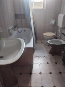 a bathroom with a sink and a tub and a toilet at B&B Albatros in Lipari