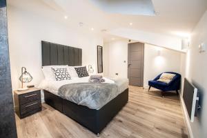 een slaapkamer met een groot bed en een blauwe stoel bij Penthouse in Liverpool City Centre in Liverpool