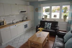 a kitchen and a living room with a couch and a table at Ferienhaus Ortgies in Carolinensiel