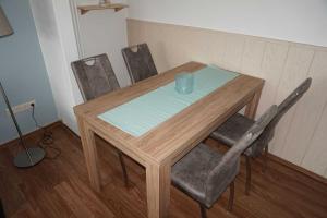 a wooden table with chairs and a blue cup on it at Ferienhaus Ortgies in Carolinensiel