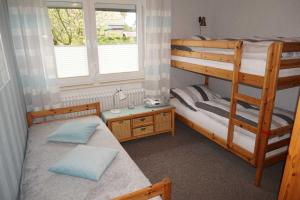 a bedroom with two bunk beds and a window at Ferienhaus Ortgies in Carolinensiel +31 photos