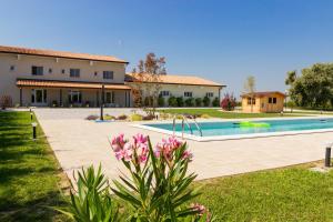 a villa with a swimming pool in front of a house at Agriturismo Ca' Manzato in Passarella