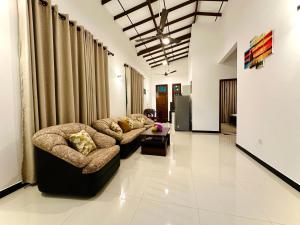 a living room with two couches and a table at Serene Bliss Villa in Unawatuna