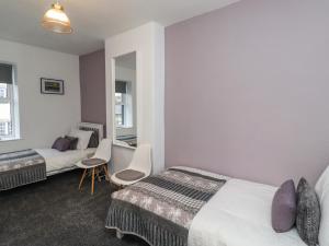 a hotel room with two beds and a mirror at 2A Front Street in Alnwick