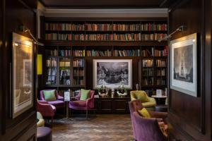 eine Bibliothek mit Bücherregalen mit Büchern in der Unterkunft Best Western Mornington Hotel Hyde Park in London