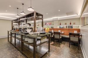 a restaurant with a counter with dishes on it at Best Western Mornington Hotel Hyde Park in London