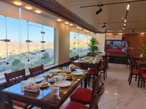 a dining room with tables and chairs and windows at Petra Crystal hotel in Wadi Musa