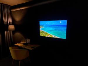 a tv hanging on a wall with a view of the ocean at Atlas Hotel in Almaty