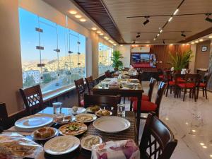 een restaurant met een lange tafel met borden eten bij Petra Crystal hotel in Wadi Musa