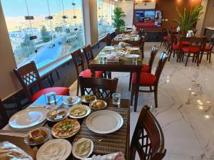 a dining room with tables with plates of food at Petra Crystal hotel in Wadi Musa