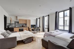 ein Wohnzimmer mit 2 Betten und eine Küche in der Unterkunft 126 Suite Abraham - Superbe Appartement à Paris in Paris