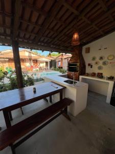 cocina con mesa de madera y banco en Casa Recanto - Villa Uryah en Caraíva