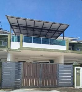 una casa con una puerta de metal y una valla en MR OT HOMESTAY ( BAITUL RAUDHAH ) en Kepala Batas