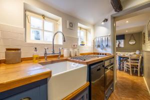 a kitchen with a sink and a stove at Yew Tree Cottage in Blakeney +27 photos