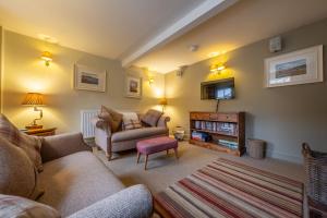 a living room with a couch and a chair at Yew Tree Cottage in Blakeney