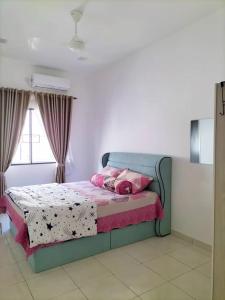um quarto com uma cama com almofadas cor-de-rosa em MR OT HOMESTAY ( BAITUL RAUDHAH ) em Kepala Batas