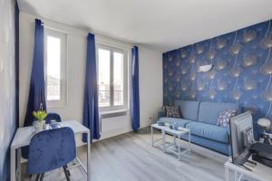 uma sala de estar com um sofá azul e paredes azuis em 807 Suite Cosy - Superb Apartment em Bagnolet