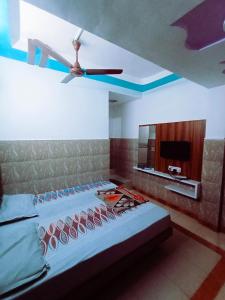 a bedroom with a bed with a ceiling fan at HOTEL ASHADEEP in Ahmedabad