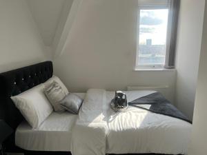 Bett in einem Zimmer mit einem großen Fenster in der Unterkunft Charming 1 bedroom Apartment In The Heart Of Manchester Close to Manchester City Centre And Etihad Stadium in Manchester