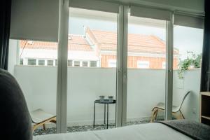 a bedroom with sliding glass doors with a view of a house at Belém Tejo - Memória by Local in Lisbon +32 photos