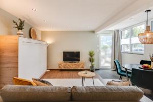 a living room with a couch and a table at Alpen Bijou mit Bergkulisse & Liebe zum Detail in Adelboden