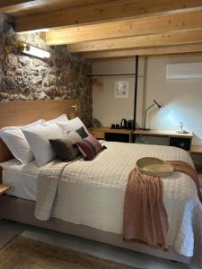 a bedroom with a large bed with white sheets and pillows at Living Yard Acropolis in Athens