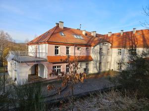 een groot wit huis met een rood dak bij Dworek Szumilas in Prudnik